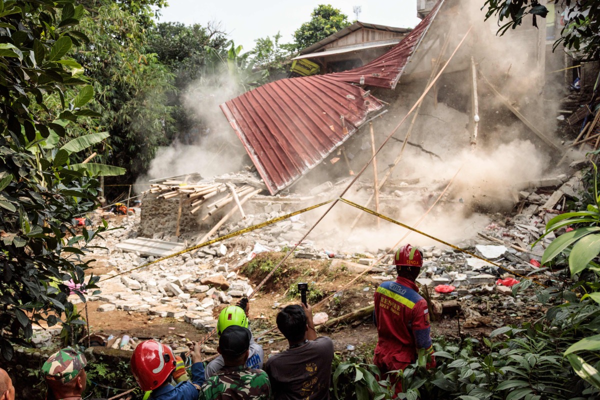 Rescue teams pull down unstable remains of a community Islamic study hall building with ropes after it collapsed while female Muslims were conducting studies in Bogor, West Java, on September 7, 2025. Photo by ADITYA AJI / AFP