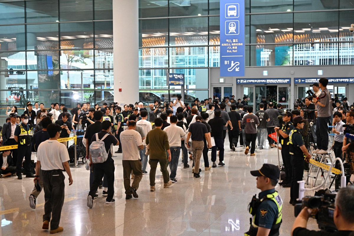South Korean workers arrive at Incheon International Airport in Incheon on September 12, 2025, after the touch down of a specially chartered Korean Air Boeing 747-81 (KE9036) bringing hundreds of South Korean workers back from Atlanta after their detention in a US immigration raid at a Hyundai-LG plant in Ellabell, Georgia. (Photo by Anthony WALLACE / AFP)