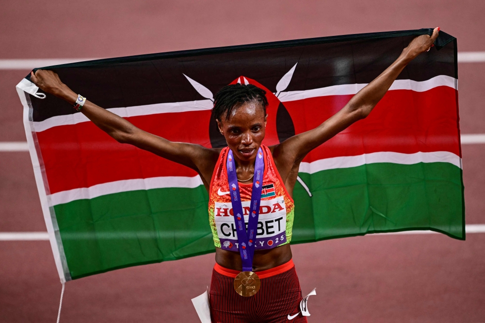 First placed Kenya's athlete Beatrice Chebet celebrates with her country's flag at the end of the women's 10000m final during the World Athletics Championships in Tokyo on September 13, 2025. (Photo by Yuichi Yamazaki / AFP)