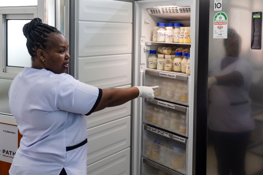 Hannah Wangeci Maina, a senior nurse gestures towards reserves donated breastmilk preserved in a freezer to await screening at a human milk bank in the Pumwani Maternity Hospital, Nairobi on September 04, 2025. (Photo by Tony Karumba / AFP)