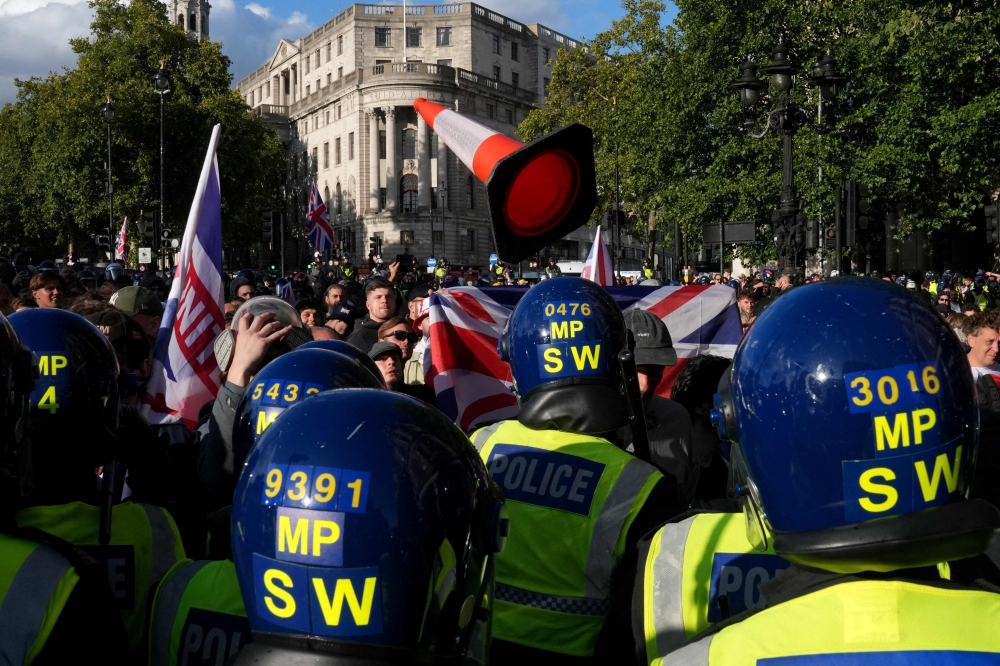 A traffic cone is thrown towards police officers as supporters of British far-right activist Tommy Robinson gather during a 'Free speech' march, in central London on September 13, 2025. (Photo by Carlos Jasso / AFP)
 