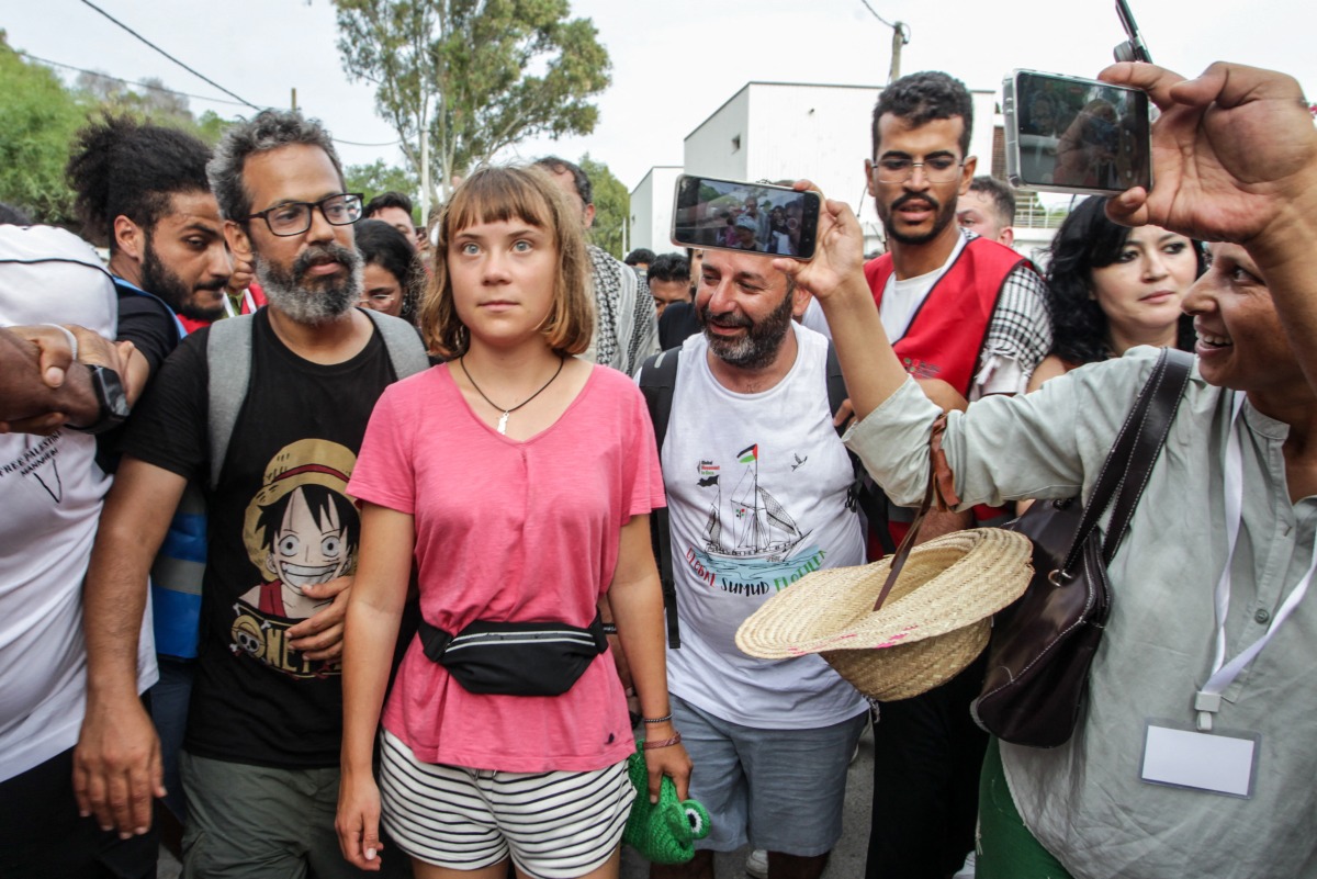 Swedish climate activist Greta Thunberg walks with a crowd of pro-Palestinian activists that arrived to greet the Global Sumud Flottila at the port of the village of Sidi Bou Said on September 7, 2025. Photo by Yassine Mahjoub / AFP