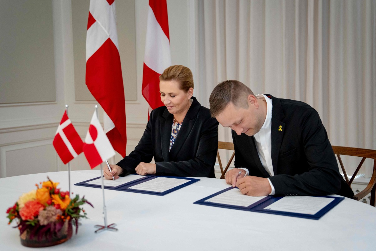 Denmark's Prime Minister Mette Frederiksen (L) and Greenland's government leader Jens Frederik Nielsen sign a framework agreement for a self-sustaining Greenland at the Prime Minister's Office in Copenhagen, Denmark, on September 16, 2025. (Photo by Mads Claus Rasmussen / Ritzau Scanpix / AFP) 