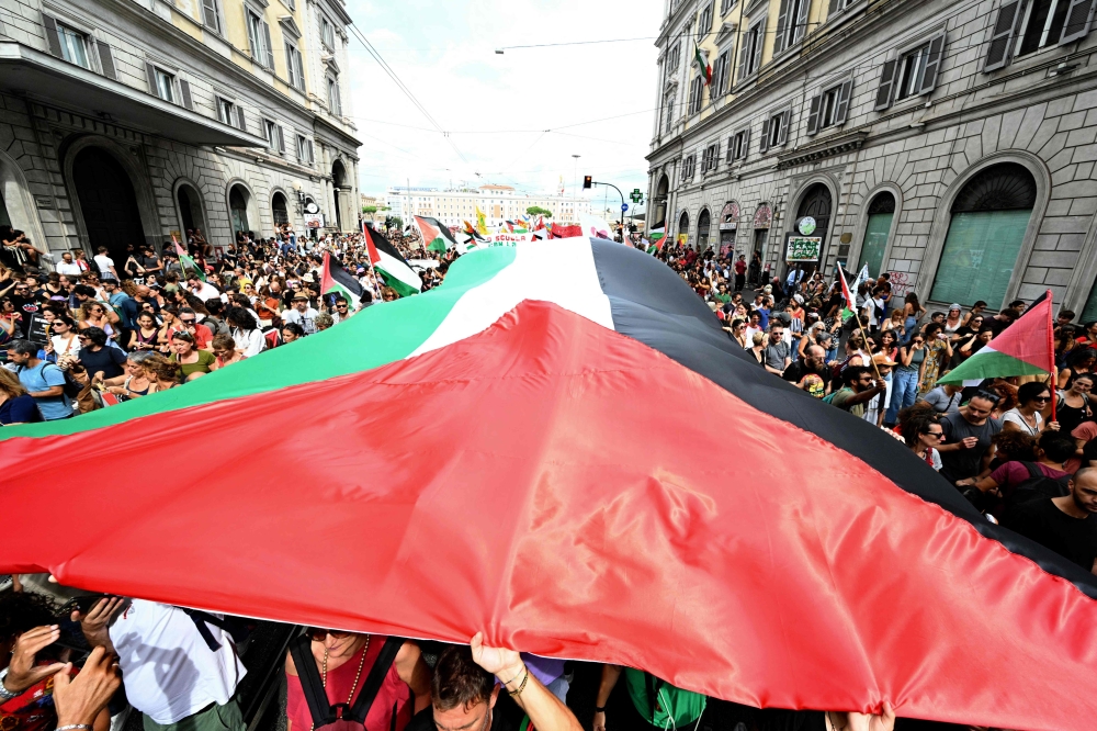 People march with a giant Palestinian flag during a nationwide strike 