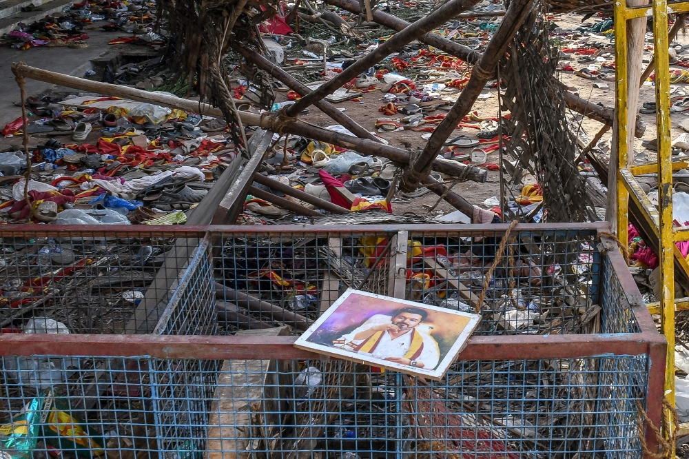 A portrait of actor-turned-politician Vijay is seen near the scattered shoes following a stampede during his political rally in the Karur district, on September 28, 2025. (Photo by AFP)