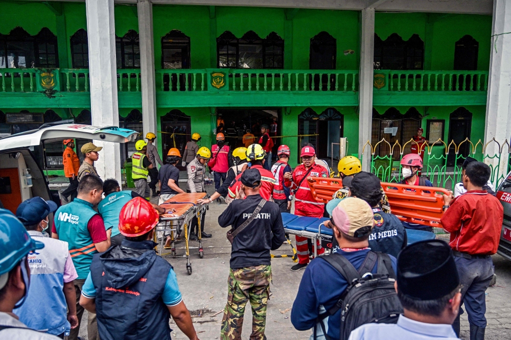 personnel search for survivors at the Al Khoziny Islamic boarding school in Sidoarjo, East Java province on September 30, 2025. (Photo by Juni Kriswanto / AFP)