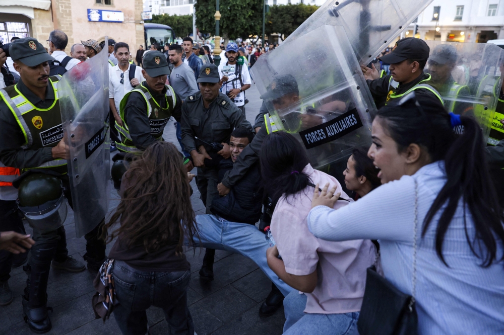 Members of the security forces detain a protester as others scuffle during a youth-led demonstration in Rabat on September 29, 2025, calling for reforms in the public health and education sectors. Dozens of youths were detained on September 29 in Morocco on the third day of protests calling for education and public health reforms, according to a local rights group and AFP reporters. (Photo by Abdel Majid Bziouat / AFP)
