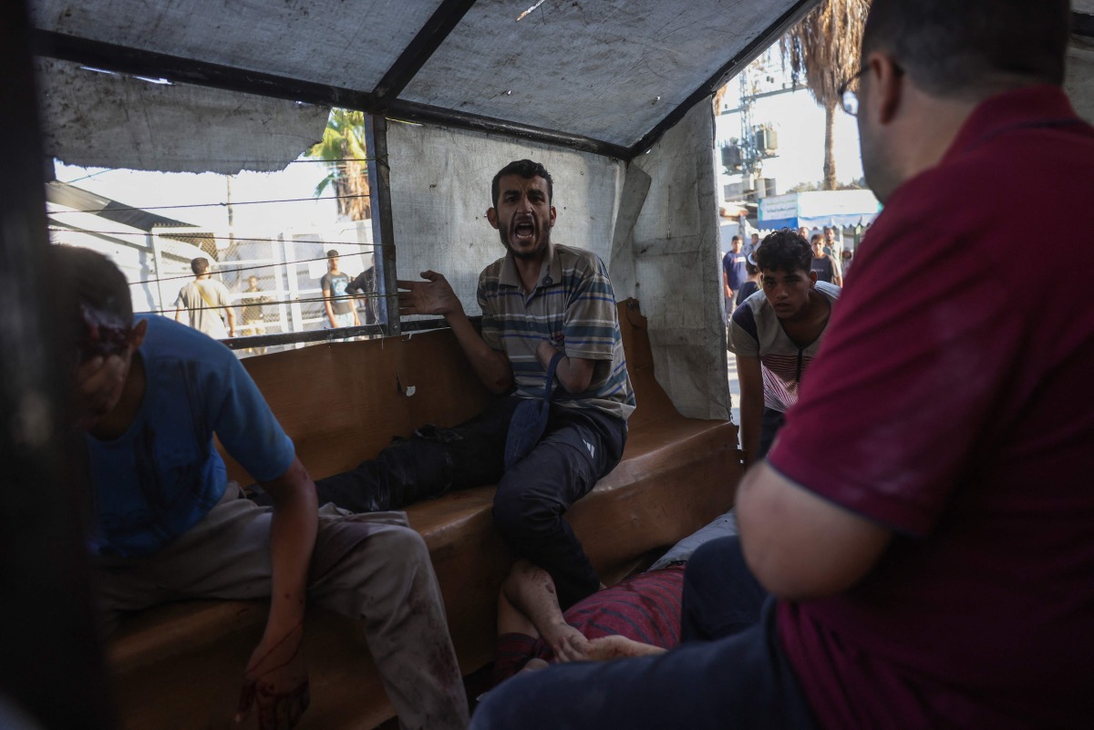 Palestinians transport casualties of a reported Israeli drone attack in Deir al-Balah, to Al-Aqsa Martyrs Hospital in the central Gaza Strip on October 2, 2025. (Photo by BASHAR TALEB / AFP)
