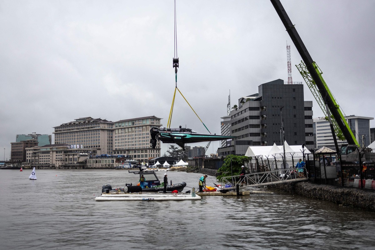 Team Drogba's E1 race boat is lowered into the Lagos Lagoon before racing in Lagos, on October 05, 2025. (Photo by OLYMPIA DE MAISMONT / AFP)