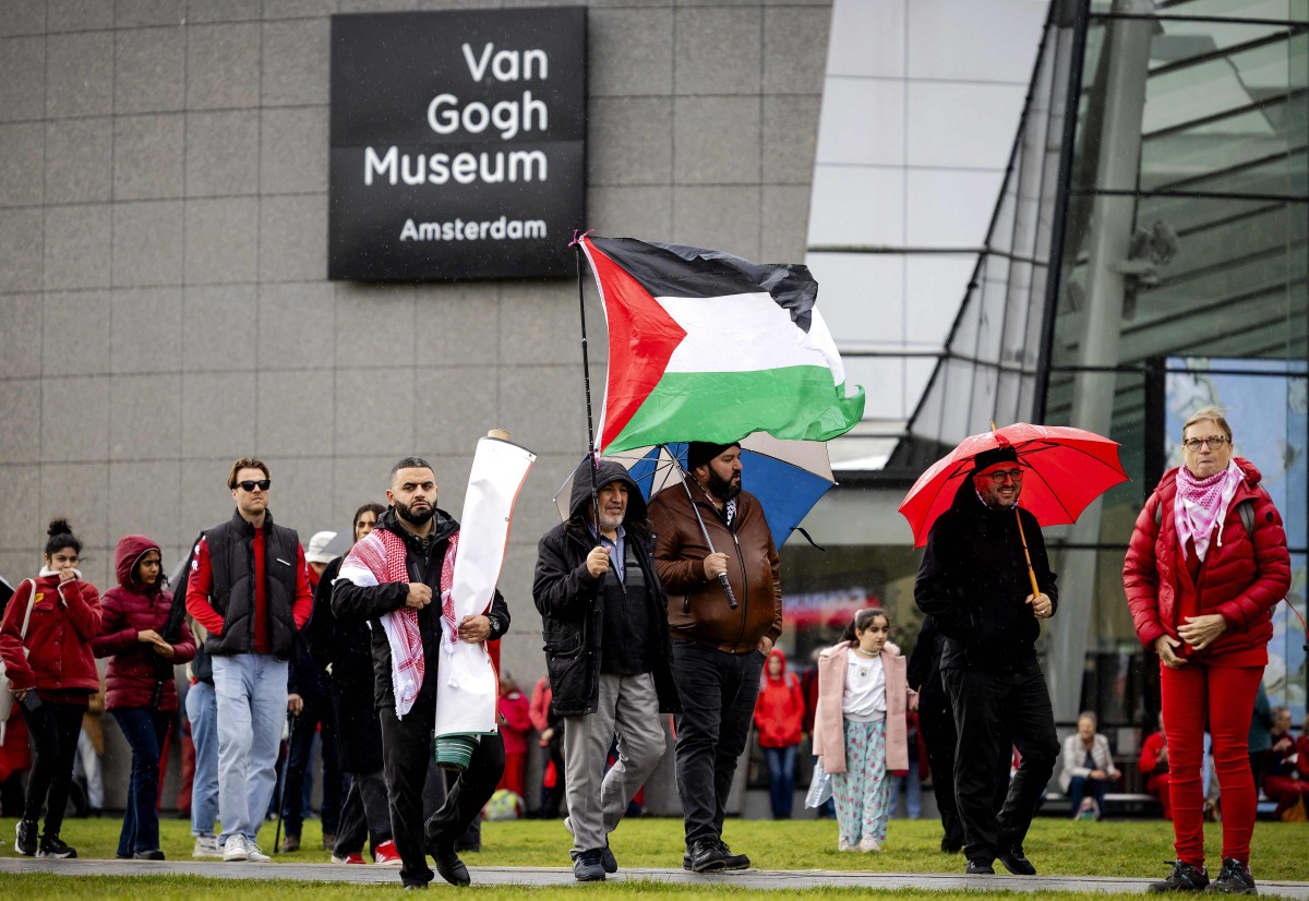 Demonstrators including one with a Palestinian flag gather at Museumplein for a 