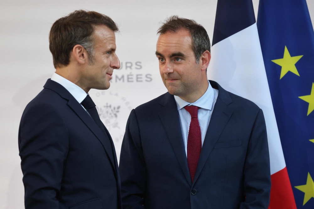 France's President Emmanuel Macron (left) with France's Minister of Armed Forces Sebastien Lecornu after delivering a speech to army leaders at l’Hôtel de Brienne in Paris on July 13, 2025. (Photo by Ludovic Marin / POOL / AFP)
