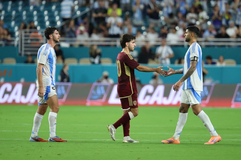 Cristian Romero of Argentina shakes hands with Matias Lacava of Venezuela after the match in Miami Garden. Photo by Leonardo Fernandez/Getty Images/AFP