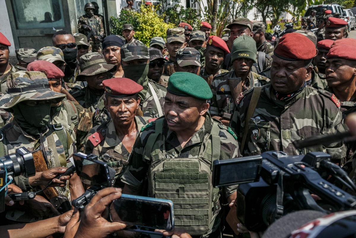 Members of a Madagascar army contingent talk to the media in a road near their camp near Antananarivo on October 11, 2025. (Photo by RIJASOLO / AFP)
