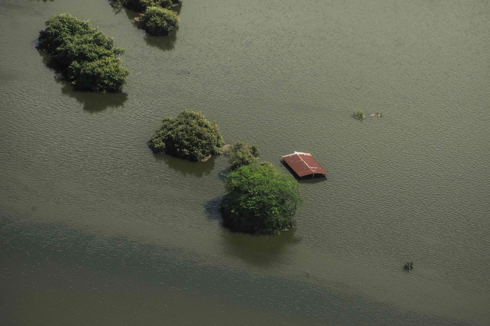 This aerial view taken during a Mexican Navy flyover shows a flooded house after heavy rains in Poza Rica, Veracruz state, Mexico on October 11, 2025. (Photo by Hector Quintanar / AFP)
 