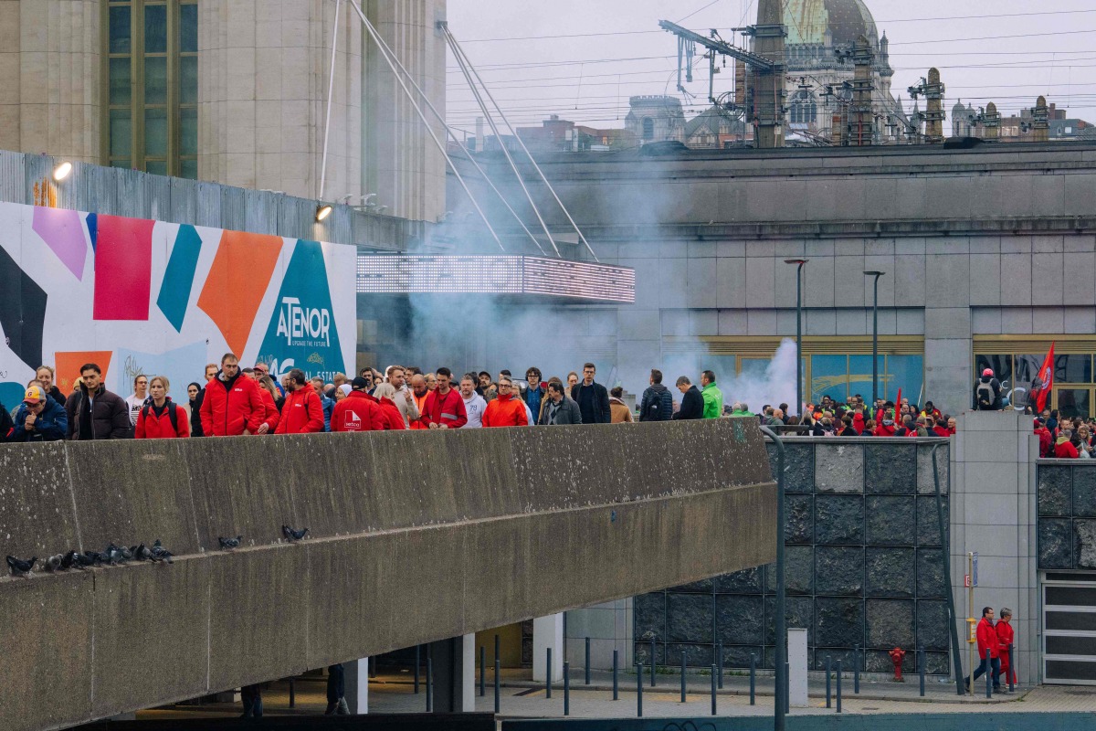 Protesters leave Gare de Bruxelles-Nord railway station as they take part in a demonstration during a national day of action against the austerity of the federal Arizona government, in Brussels on October 14, 2025. (Photo by Marius Burgelman / Belga / AFP)