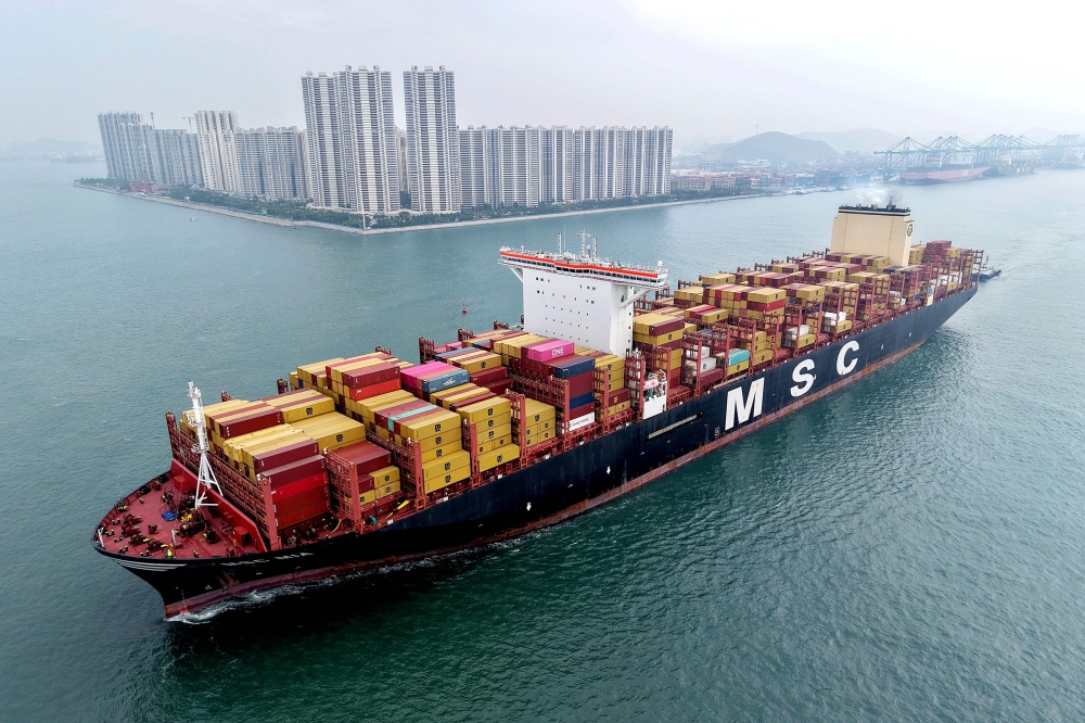 (Files) This aerial view shows a container ship moving towards its berth at the container terminal of the port in Qingdao, in China's eastern Shandong province, on September 24, 2025. (Photo by AFP) 