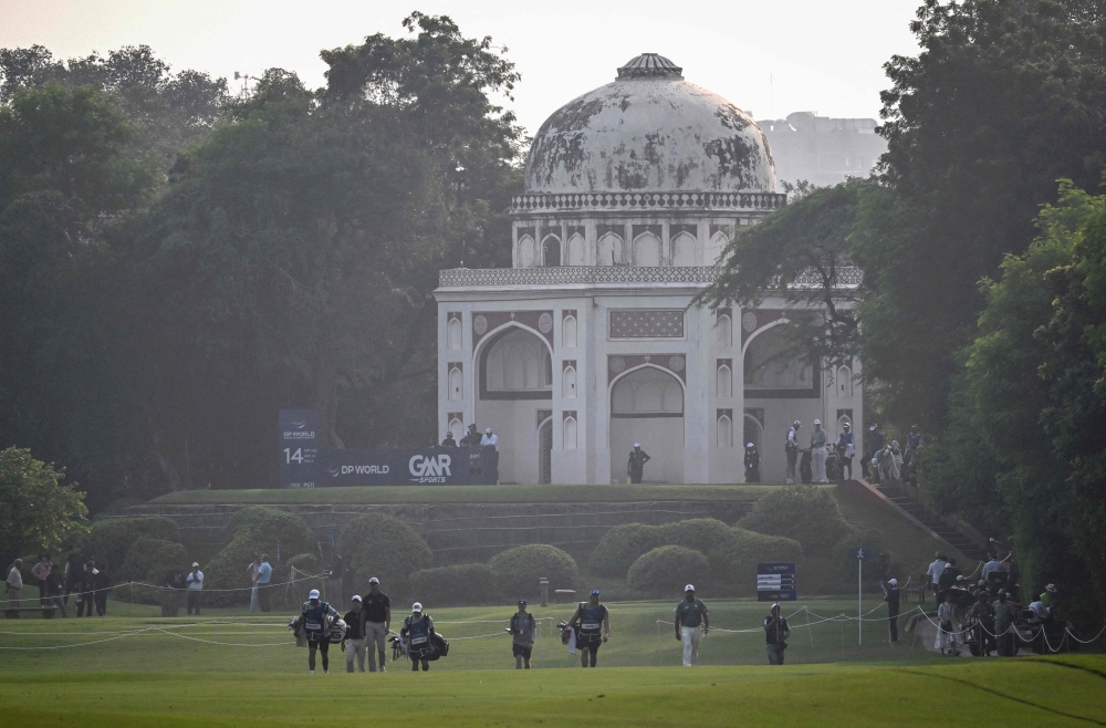 Participants walk on a golf course beside a Mughal-era heritage monument during the DP World India Championship 2025 golf tournament on October 17, 2025. (Photo by Arun Sankar / AFP)