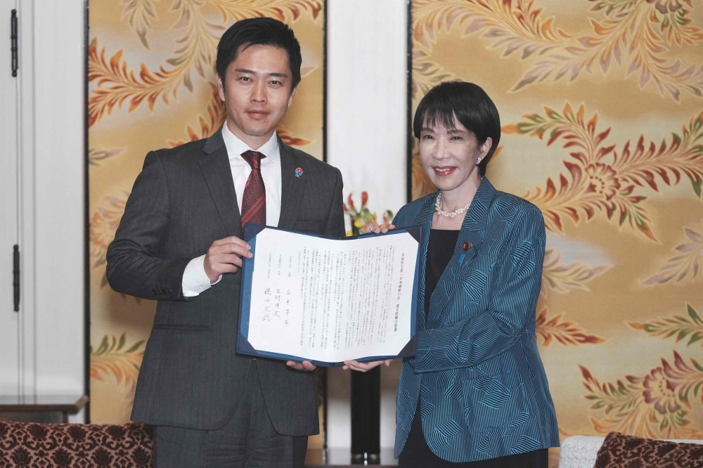 Japan's ruling Liberal Democratic Party (LDP) President Sanae Takaichi (R) and Japan Innovation Party (JIP) leader Hirofumi Yoshimura pose for the media on October 20, 2025. (Photo by Kazuhiro Nogi / AFP)