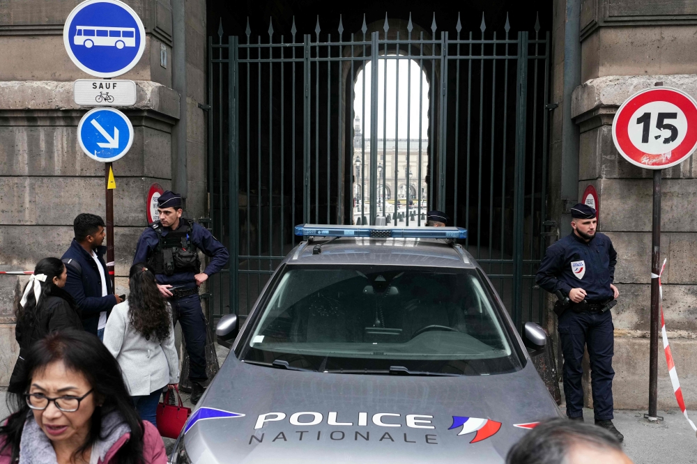 French police officers stand in front of the Louvre Museum after a robbery, in Paris on October 19, 2025. (Photo by Dimitar Dilkoff / AFP)