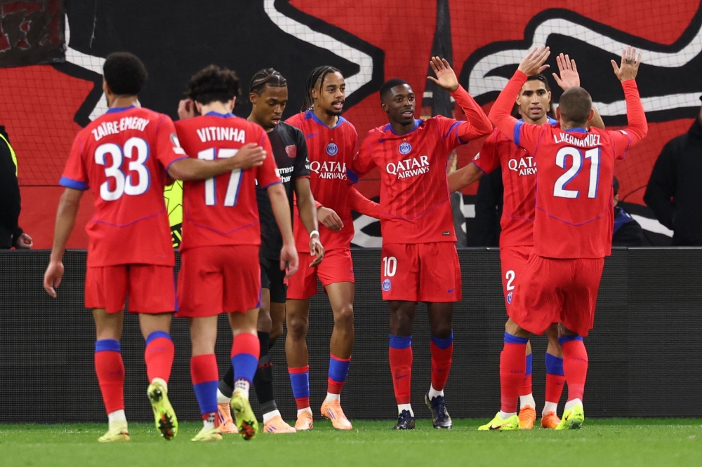 Paris Saint-Germain (PSG) players celebrate win against Bayer 04 Leverkusen at the UEFA Champions League at the BayArena stadium in Leverkusen, western Germany on October 21, 2025. (Photo by Franck Fife / AFP)