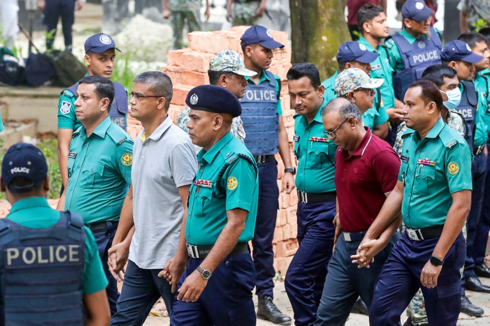 Police personnel escort detained army officers to the International Crimes Tribunal court in Dhaka on 22 October 2025. Photo by AFP