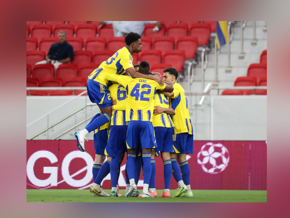 Al Gharafa players celebrate after scoring a goal.