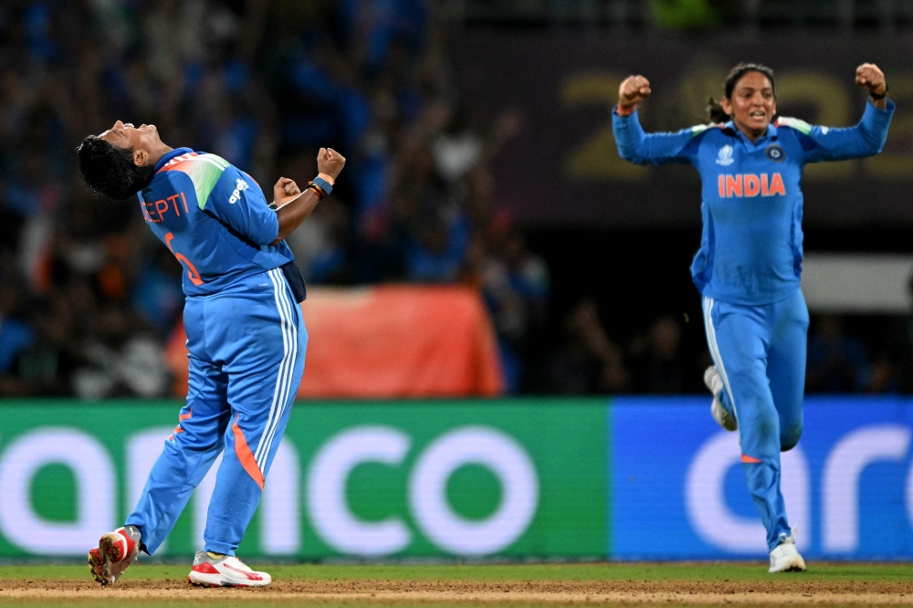 India's Deepti Sharma (left),  team captain Harmanpreet Kaur celebrate during the ICC Women's Cricket World Cup 2025 one-day international (ODI) final match between India and South Africa at the DY Patil Stadium in Navi Mumbai on November 2, 2025. (Photo by Punit Paranjpe / AFP)