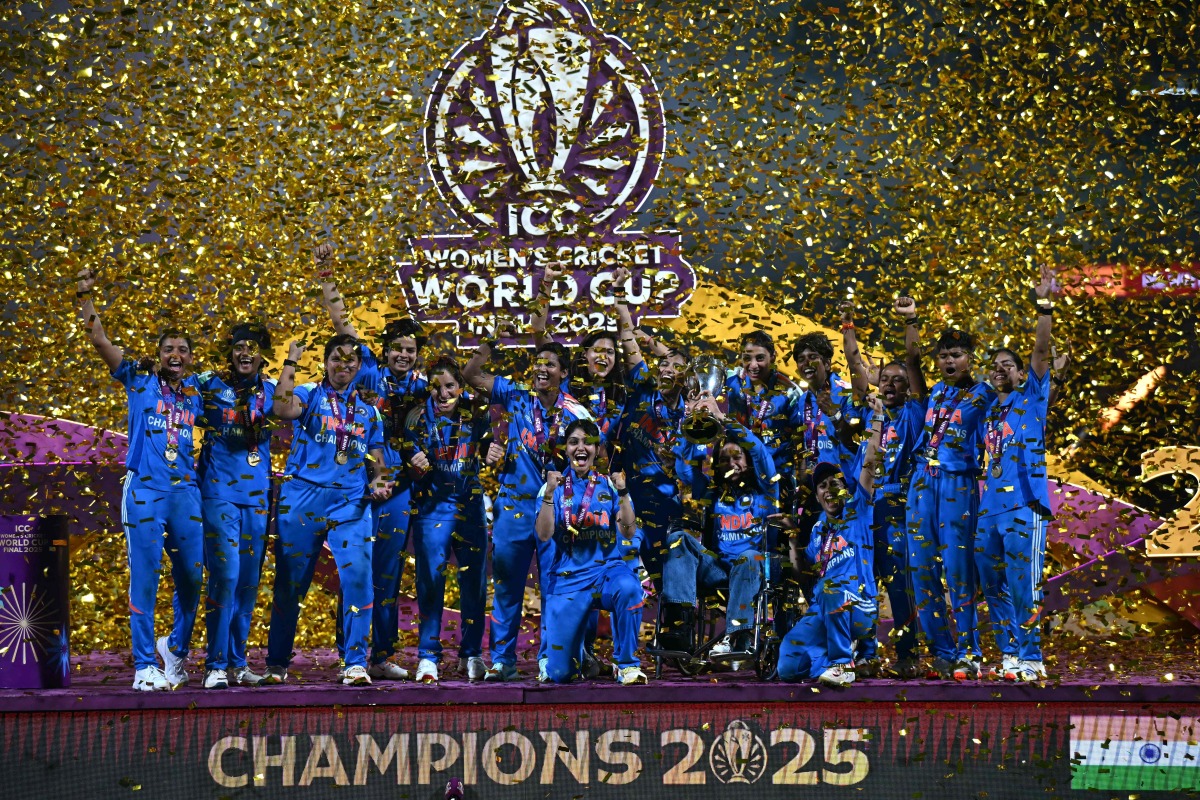 India's players celebrate with the trophy after winning the ICC Women's Cricket World Cup 2025 one-day international (ODI) final match between India and South Africa at the DY Patil Stadium in Navi Mumbai on November 3, 2025. (Photo by Punit PARANJPE / AFP)