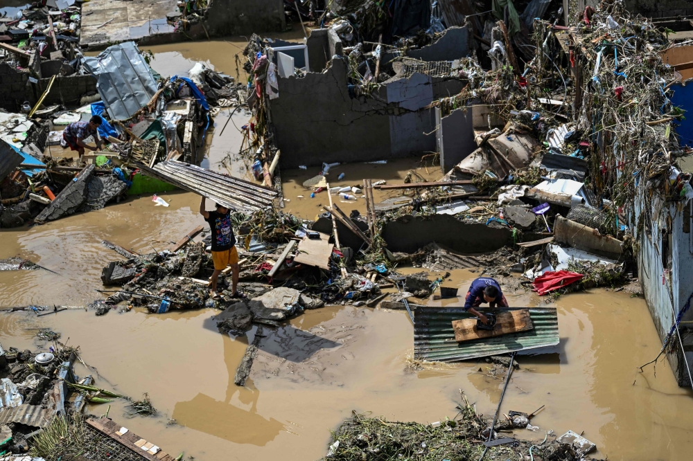 Residents pick up debris from their damaged houses in the aftermath of Typhoon Kalmaegi in Talisay, in the province of Cebu on November 5, 2025. (Photo by Jam Sta Rosa / AFP