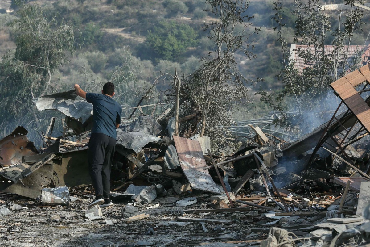 A man stands amid the debris at the site of an Israeli airstrike in the southern Lebanese village of Toura on November 6, 2025. (Photo by MAHMOUD ZAYYAT / AFP)