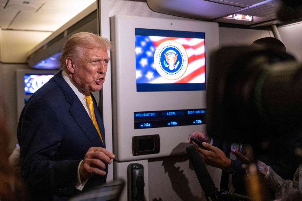 US President Donald Trump speaks to members of press aboard Air Force One on November 14, 2025 while in flight from Washington, DC to West Palm Beach International Airport. Roberto Schmidt/Getty Images/AFP 