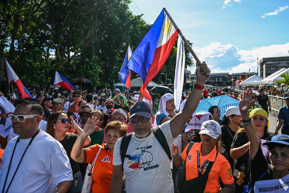 Protesters wave flags and shout slogans during an anti-corruption rally in Quezon City, Metro Manila on November 16, 2025. (Photo by Jam STA ROSA / AFP)