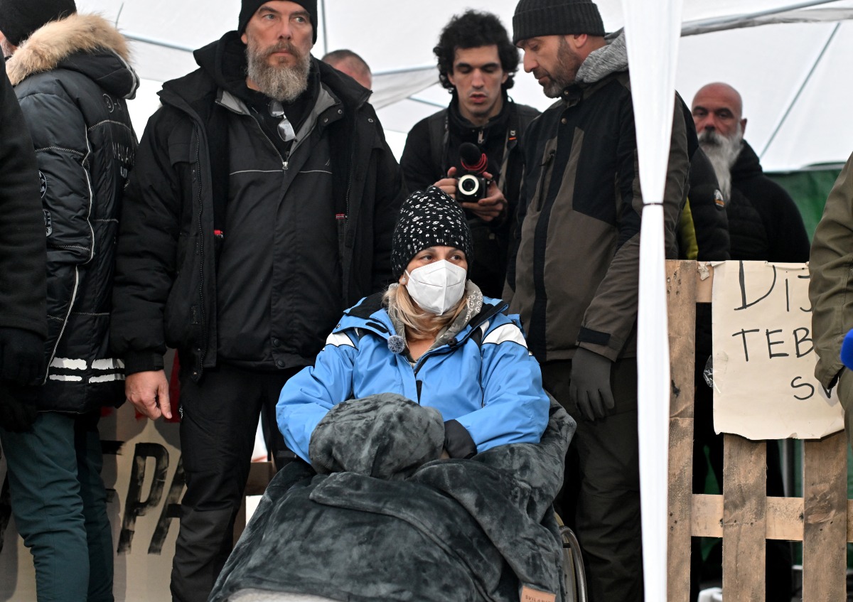 Dijana Hrka (C), the mother of one of the victims of the Novi Sad train station tragedy, addresses the media on the 11th day of her hunger strike in front of the Serbian National Assembly in Belgrade, on November 12, 2025. Photo by OLIVER BUNIC / AFP