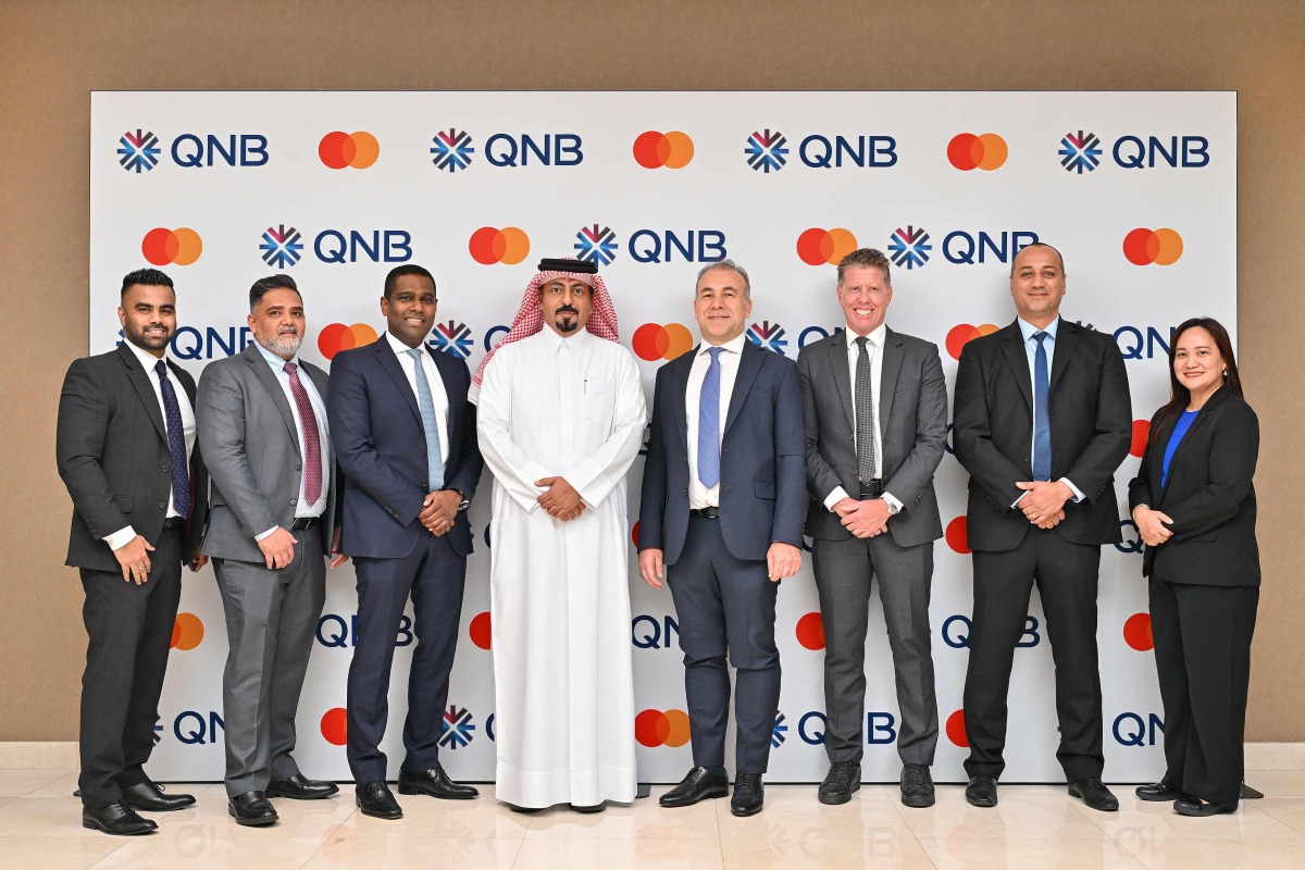 QNB and Mastercard senior executives pose for a goup photo during the signing ceremony.