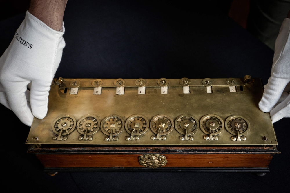 (Files) This photograph shows La Pascaline, first mechanical calculating machine invented by French polymathe Blaise Pascal displayed at the Christie's auction house in Paris, on September 11, 2025. (Photo by Stephane De Sakutin / AFP)