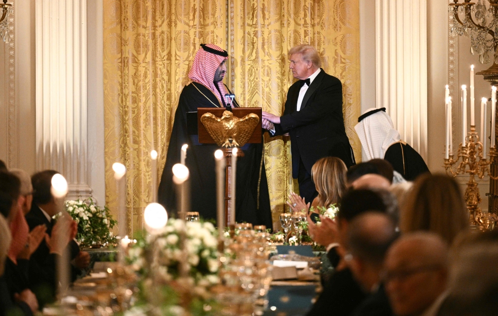 US President Donald Trump (R) shakes hands with Crown Prince and Prime Minister of the Kingdom of Saudi Arabia HRH Mohammed bin Salman bin Abdulaziz Al Saud during an official dinner in Washington, DC on November 18, 2025. (Photo by Brendan Smialowski / AFP)