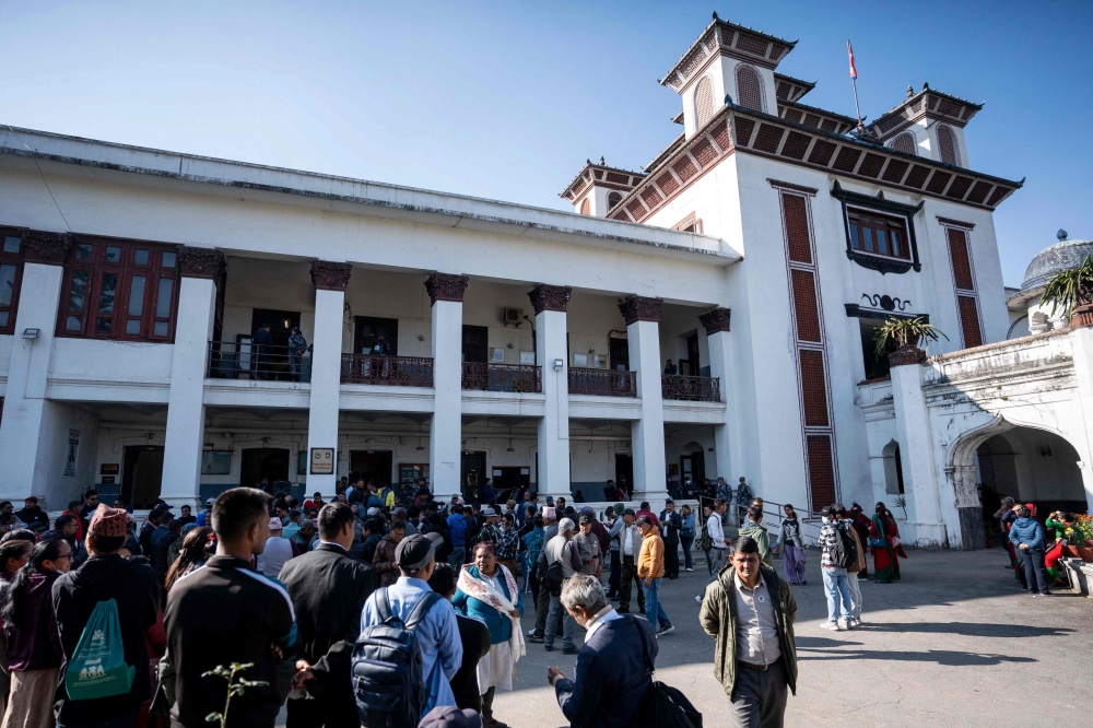 This photograph taken on November 18, 2025 shows supporters and representatives of various political groups gathering outside the Election Commission office in Kathmandu, as officials process new party registrations ahead of Nepal's parliamentary elections. (Photo by Prabin Ranabhat / AFP) 