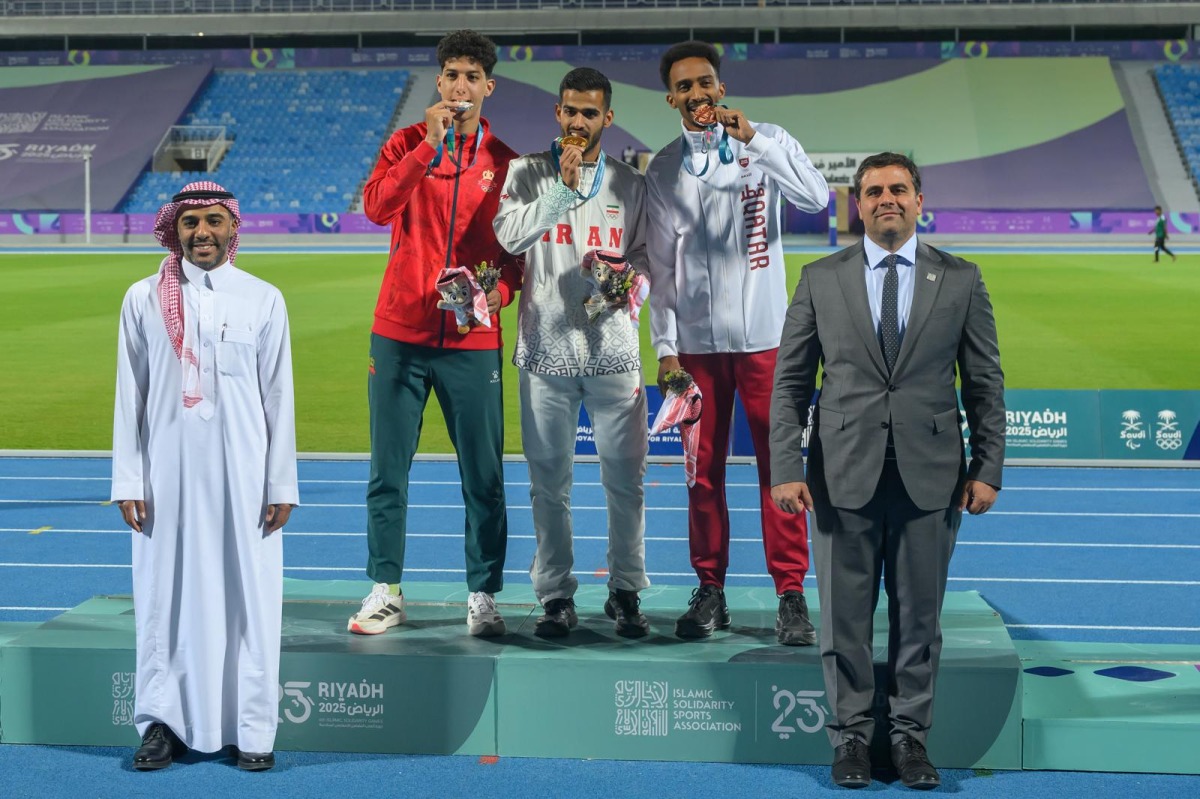 Qatar's Abubaker Haydar (right) celebrates with the gold and silver medal winners on the podium.