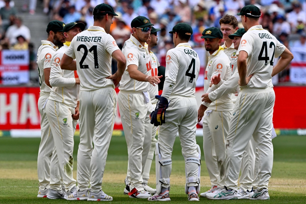 Australian players wait for the third umpire decision on England's Jamie Smith dismissal on day 2 of the first Ashes cricket Test match between Australia and England at Perth Stadium in Perth on November 22, 2025. (Photo by Saeed Khan / AFP) /