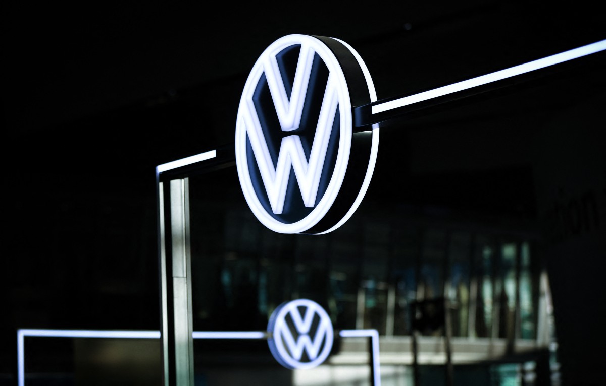 The illuminated VW Logo is pictured in the customer centre at the headquarters of German carmaker Volkswagen (VW) in Wolfsburg, central Germany, on November 21, 2025. (Photo by Ronny Hartmann / AFP)
