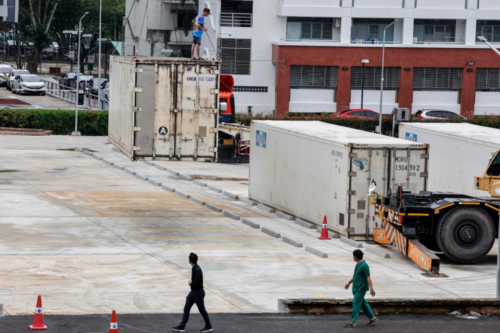 Refrigerated containers are installed to store the bodies of flood victims outside Songklanagarind Hospital in Hat Yai in Thailand's southern Songkhla province on November 28, 2025. (Photo by Sarot Meksophawannakul / Thai News Pix / AFP)
