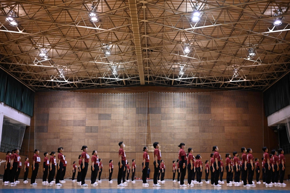 Students of Nippon Sports Science University rehearse for their annual synchronised walking performance, known as Shudankodo, in Yokohama on November 26, 2025. (Photo by Greg Baker / AFP)
