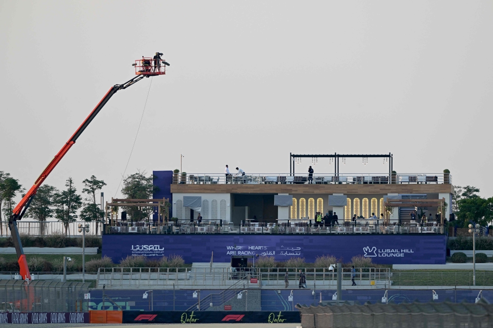 Workers prepare a stand at the Lusail International Circuit ahead of the Formula One Qatar Grand Prix in Lusail on November 27, 2025. (Photo by Mahmud Hams / AFP)