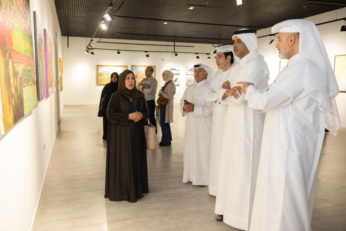 Officials and visitors view paintings on display at Katara during an exhibition held in connection with the FIFA Arab Cup Qatar 2025.   