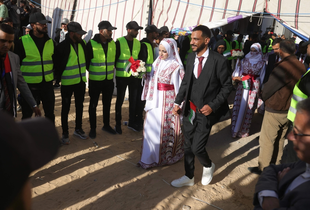 A bride and groom arrive for a mass wedding of 54 couples, dubbed the 