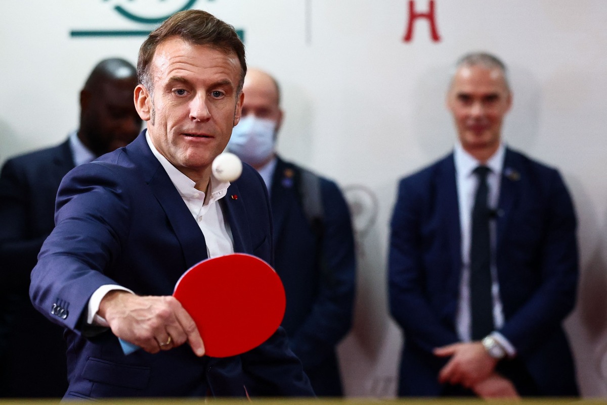 French President Emmanuel Macron plays table tennis during a meeting with Chinese and French table tennis players and students at Sichuan University in Chengdu, in southwestern China's Sichuan province on December 5, 2025. (Photo by Sarah Meyssonnier / POOL / AFP)