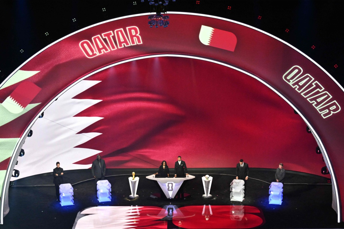 Qatar's flag is displayed on a screen during the draw for the 2026 FIFA Football World Cup taking place in the US, Canada and Mexico, at the Kennedy Center, in Washington, DC, on December 5, 2025. (Photo by Roberto SCHMIDT / AFP)
