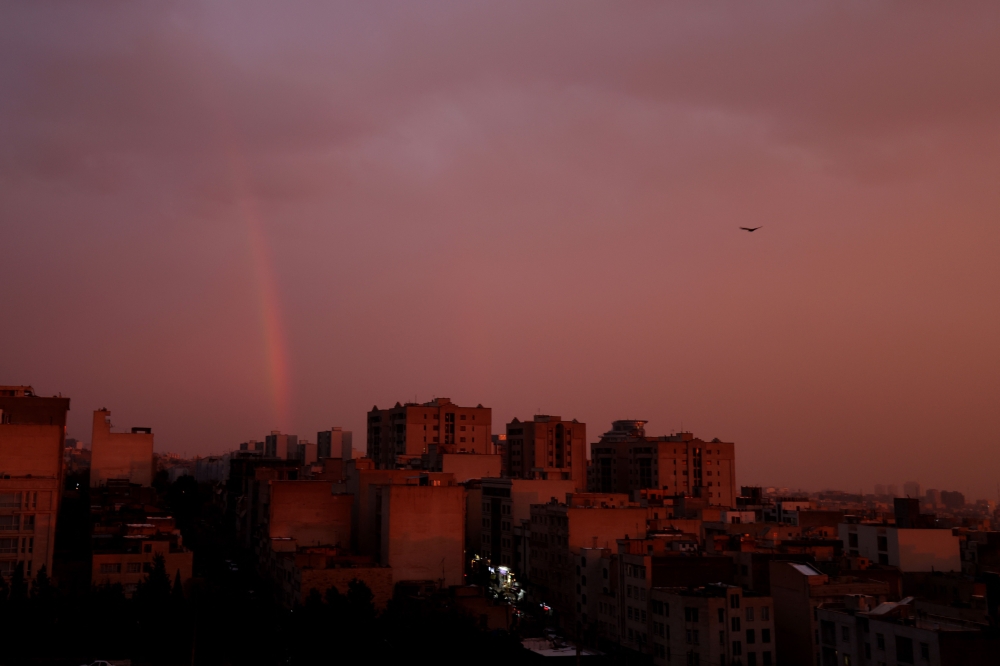 A general view of a rainbow at sunset following several days of rain in the Iranian capital Tehran on December 10, 2025. (Photo by Atta Kenare / AFP)