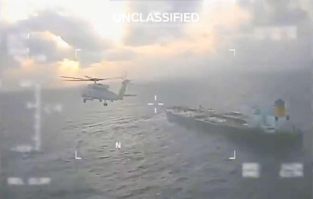 This screen grab taken from a video posted on the X account of US Secretary of Homeland Security Kristi Noem shows a US Coast Guard aircraft flying over a crude oil tanker, last docked in Venezuela, before apprehending it on December 20, 2025. (Photo by Handout / US Secretary of Homeland Security Kristi Noem's X account / AFP) 