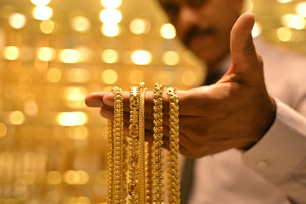 (Files) A salesman displays gold chains at a jewellery store in Bengaluru on September 17, 2025. (Photo by Idrees Mohammed / AFP)